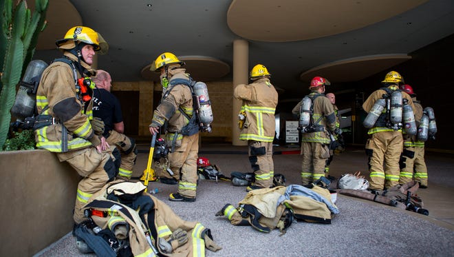 The Phoenix Fire Department gathers in the Sheraton garage after a fire caused all occupants of a downtown hotel to evacuate October 25, 2014 in Phoenix.