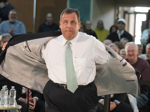 New Jersey Governor Chris Christie takes off his jacket
