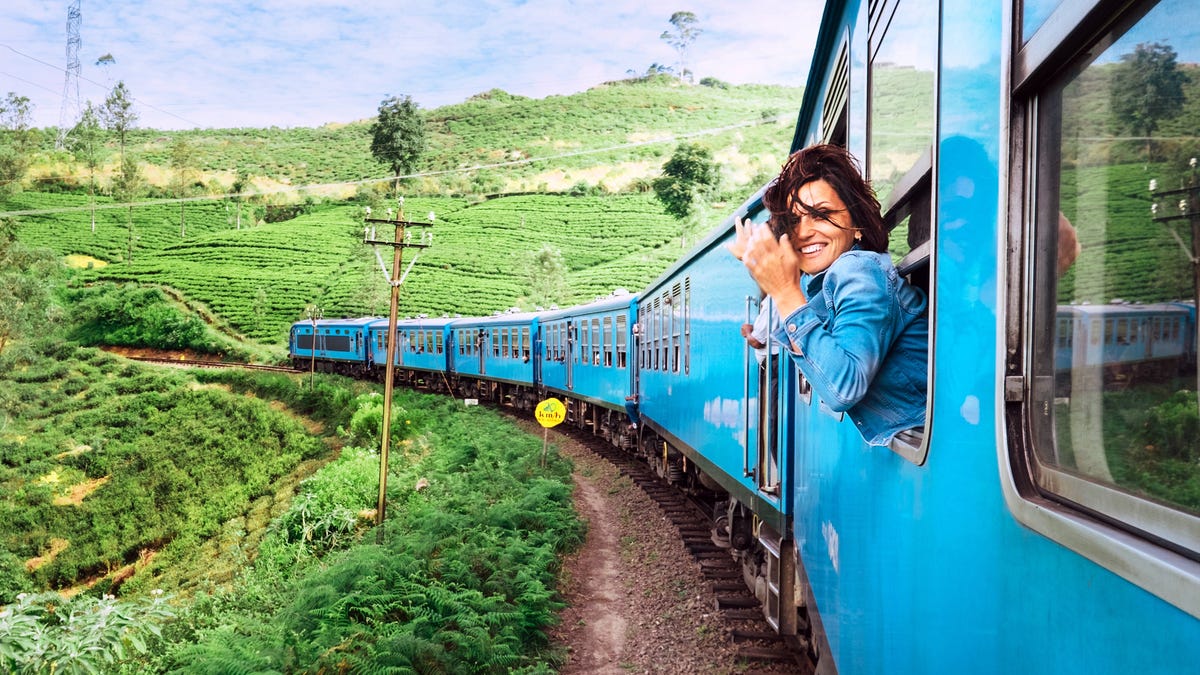 A woman sticking her head out of a moving train