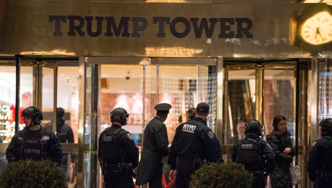 New York police officers and others stand outside the Trump Tower lobby in New York, Tuesday, Dec 27, 2016. Police hastily cleared the lobby of Trump Tower on Tuesday to investigate an unattended backpack, only to find that the bag contained children's toys.