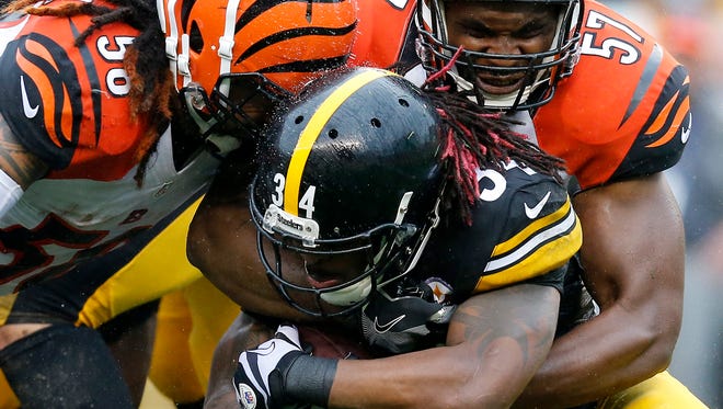 Pittsburgh Steelers running back DeAngelo Williams (34) is taken down by Cincinnati Bengals middle linebacker Rey Maualuga (58) and outside linebacker Vincent Rey (57) in the first quarter of the NFL Week 2 game between the Pittsburgh Steelers and the Cincinnati Bengals at Heinz Field in Pittsburgh on Sunday, Sept. 18, 2016. At the half, the Bengals trailed 10-6.