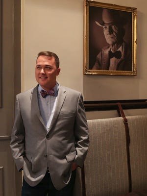 Chris Diebel, owner of one of Des Moines' newest restaurants, Bubba, poses for a photo next to a portrait of his great grandfather in one of the dining areas of the restaurant
