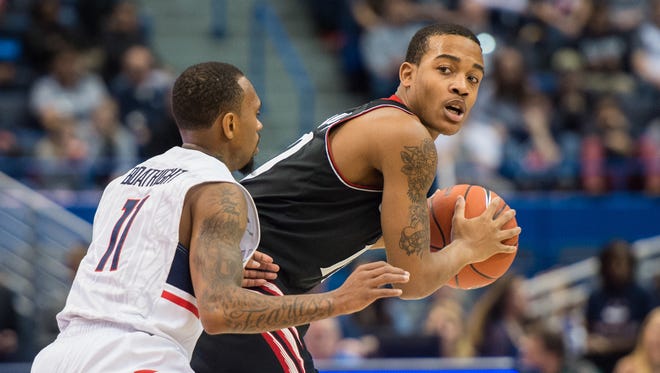 Bearcats guard Troy Caupain is defended by Connecticut guard Ryan Boatright on Jan. 10.