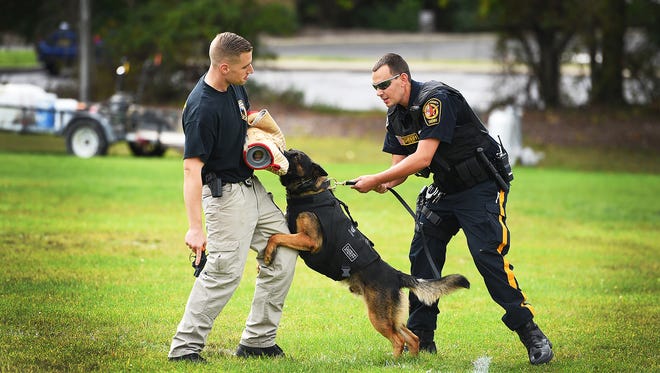 K9 Gino, wearing a bullet-proof vest that was donated, performs a demonstration with two officers, Scott Phillips, left, and Keith Heyman at the Wayne Township Memorial First Aid Squad on Wednesday.