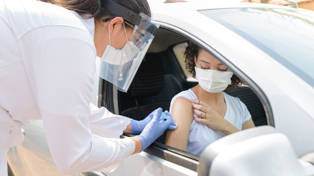 Car passenger receiving a vaccination shot.