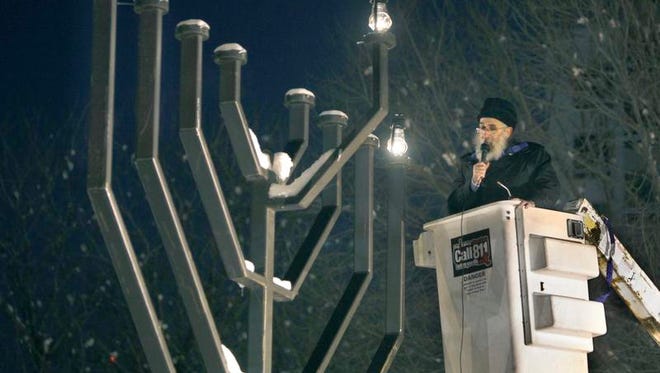 Rabbi Nechemia Vogel sings as he lights the downtown menorah during a ceremony at Washington Square Park Wednesday to mark the beginning of Hanukkah.