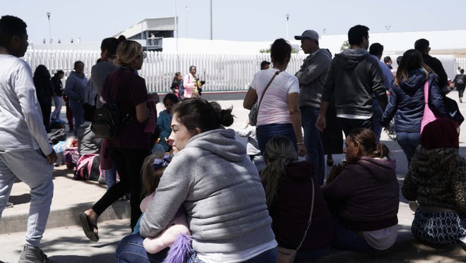 Migrants waits near The El Chaparral port of entry border crossing on April 28, 2018.