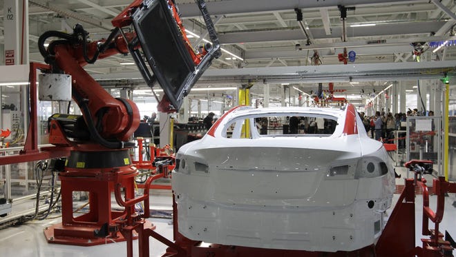 A robot puts on the top of a Tesla Model S at the Tesla factory in Fremont, Calif., in 2012. Northern Nevada and California are among the sites being considered for the company’s planned battery factory.