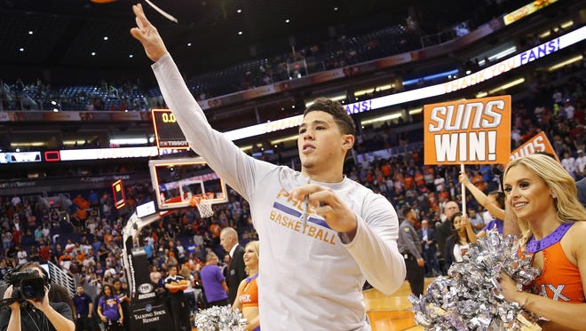 Phoenix Suns guard Devin Booker (1) throws his shoe into the crowd after beating the Dallas Mavericks 124-111 in their final home game of the season at Talking Stick Resort Arena in Phoenix, Ariz. April 9, 2017.