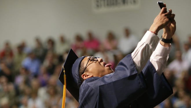 Andrew Choi gets the crowd laughing as he takes a selfie as part of his speech during the Appleton North High School graduation ceremony last June.