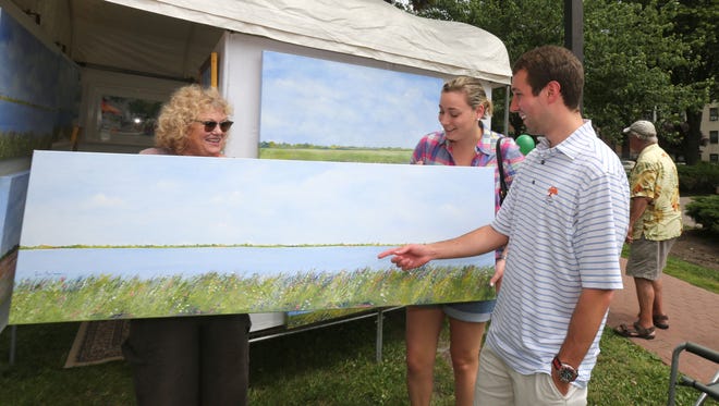 Artist Jean Andrew, chats with Peyton and Maxwell Kasak from Scarsdale, they bought one of her paintings during the 54th annual White Plains Outdoor Arts Festival at Tibbits Park in White Plains, June 4, 2016. 