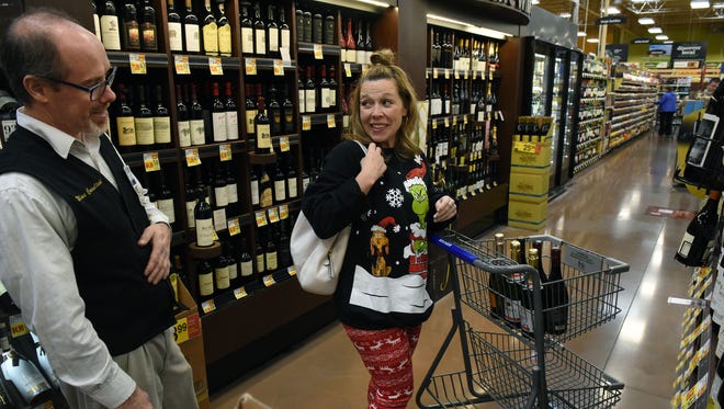 Cedar Bluff Kroger Marketplace wine steward Kevin Valley, left, tells customer Megan Collins she get another discount if she buys six more bottles Thursday, Dec. 21, 2017. Stores in Tennessee will not be able to sell wine and beer on Christmas and New Years Eve because they fall on Sunday this year. 