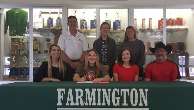 Farmington's Lexie Jackson, center, signs a letter of intent to play volleyball for New Mexico Military Institute on April 27 at Farmington High School.