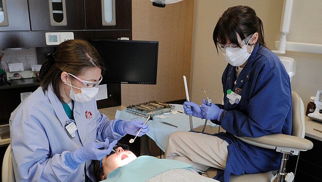Dr. Katelin Ratliff, (left) and dental assistant Amber Keding work in this file photo with patient Hilda Schwinn of Marshfield at the Family Health Center of Marshfield Dental Center, operated in conjunction with Marshfield Clinic.