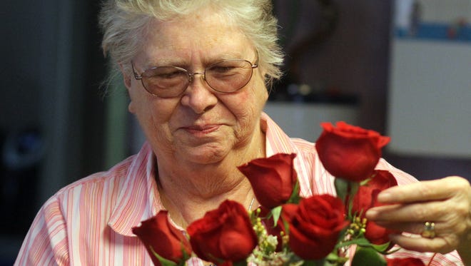 Lois Tharp works on a bouquet of red roses that will soon touch someone's heart.