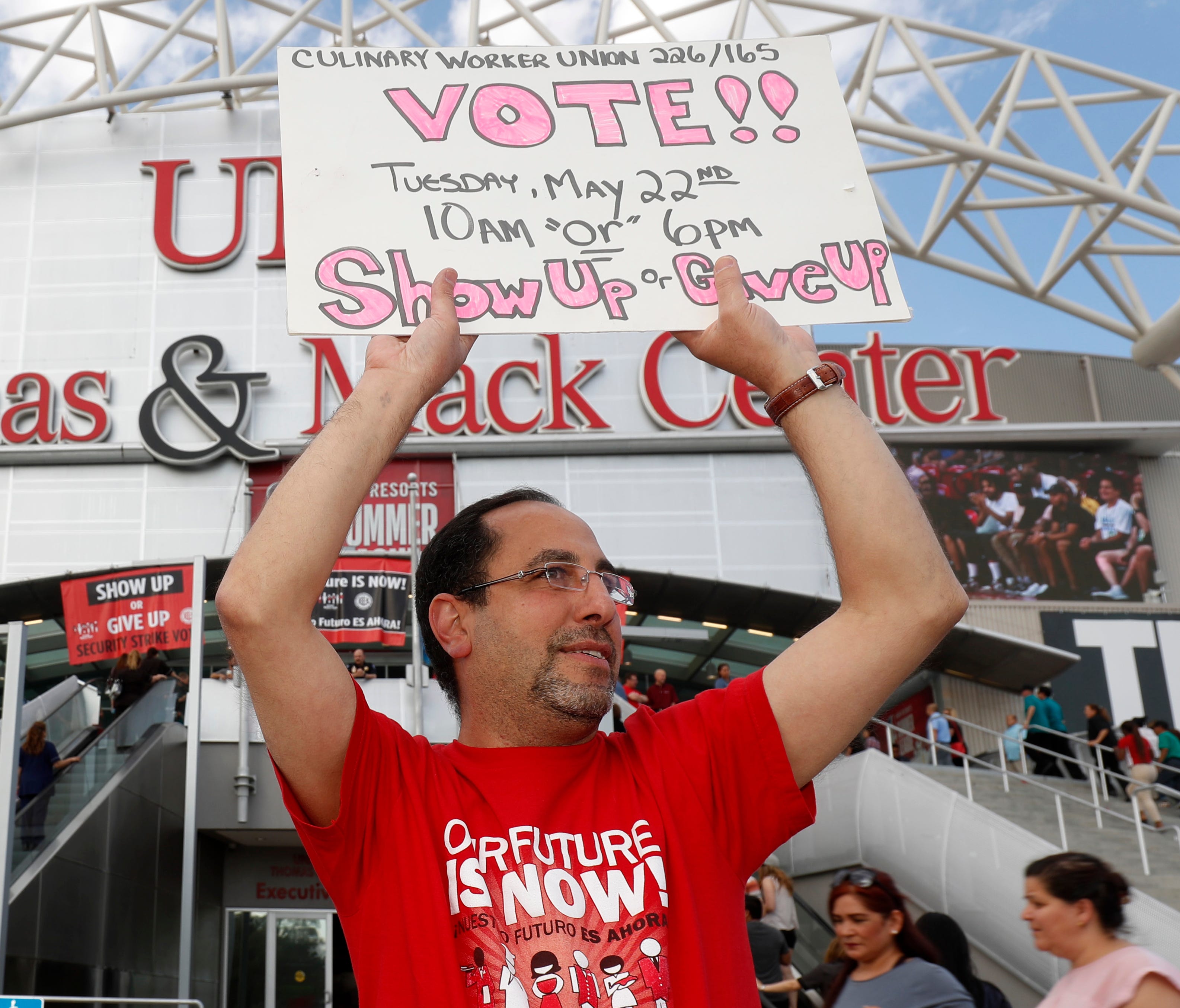 Union organizers hold signs as members of the Culinary Workers Union, Local 226, file into a university arena in Las Vegas where they voted to authorize a strike in the city's casinos. The vote will not immediately affect the casinos, but it would gi