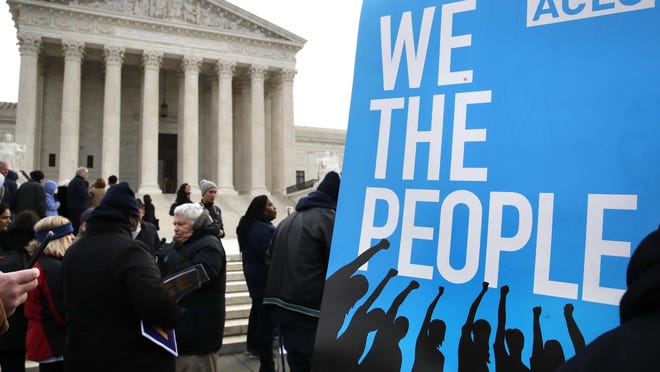 FILE - In this Jan. 10, 2018, file photo, people rally outside of the Supreme Court in opposition to Ohio's voter roll purges in Washington. The Supreme Court is allowing Ohio to clean up its voting rolls by targeting people who haven't cast ballots in a while. The justices are rejecting, by a 5-4 vote on June 11, 2018, arguments that the practice violates a federal law that was intended to increase the ranks of registered voters.(AP Photo/Jacquelyn Martin, File)