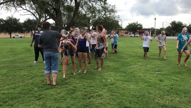 McMurry University incoming freshmen rinse off after participating in the Slime Olympics on Saturday, Aug. 26, 2017.