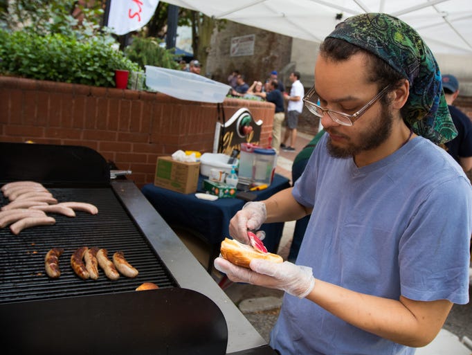Darian Roswall, of King Brat, prepares a wurst during