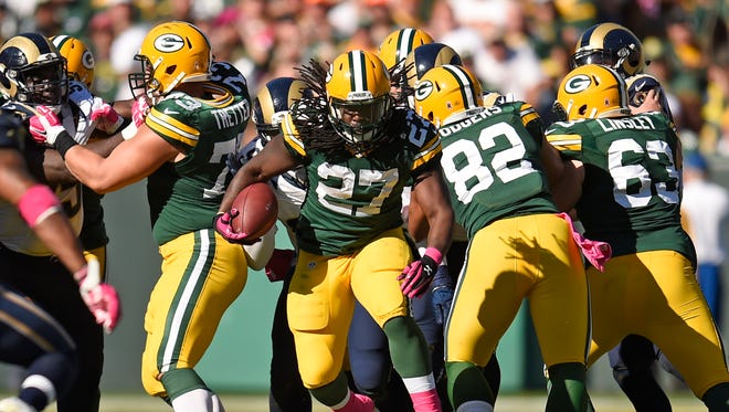 Green Bay Packers running back Eddie Lacy (27) bursts through the line of scrimmage as teammates block against St. Louis Rams at Lambeau Field October 11, 2015.