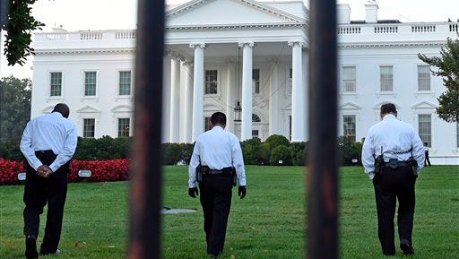 Uniformed Secret Service officers walk along the lawn on the North side of the White House in Washington, Saturday, Sept. 20, 2014. The Secret Service is coming under renewed scrutiny after a man scaled the White House fence and made it all the way through the front door before he was apprehended.  (AP Photo/Susan Walsh)