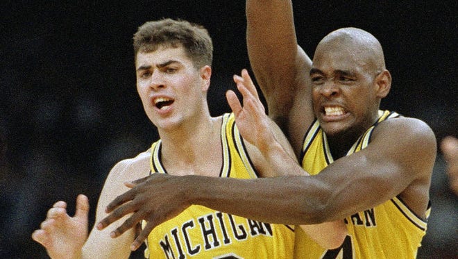 Michigan's Chris Webber and Rob Pelinka (3) celebrate in New Orleans after defeating Kentucky, 81-78, in overtime on April 3, 1993.