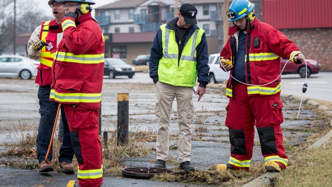Members of the Delaware County HAZMAT team work on clearing fuel from the storm water drainage lines after it was dumped from a floor drain at the Phillips 66 gas station on the corner of Wheeling and Centennial avenues.