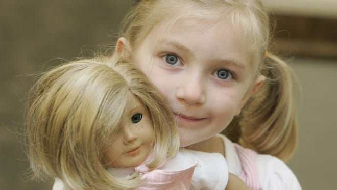 Grace Hedenberg, 6, of Zionsville holds the "American Girl" doll she brought to an "American Girl"  tea party held at the Hussey-Mayfield Public Library in Zionsville in . Girls K-2 gathered at the Hussey-Mayfield Public Library in Zionsville in July 2009. Girls dressed as their favorite "American Girl" from the "American Girl"  doll for a tea party which included stories and games.