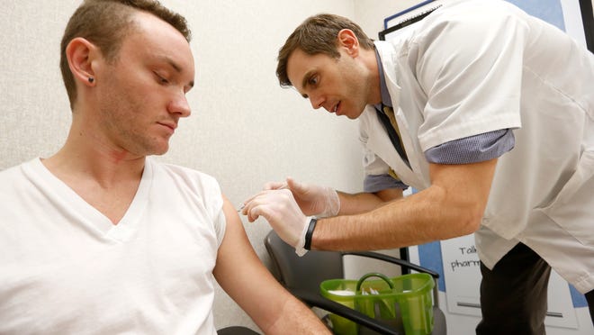Trevor Hayworth, an FSU student, gets a flu shot administered by Eric Hand, the pharmacy manager at Walgreens on Monroe Street in Tallahassee. Hayworth said he has been getting flu shots for the last four years and has successfully avoided the illness during that time.