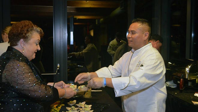 Chef Jack Strong serves a guest one of his oyster creations at 2014's Oyster Cloyster.