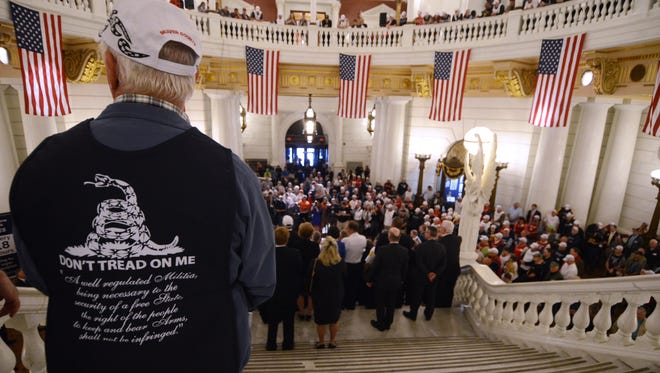 People watch as supporters of gun rights crowd the Capitol rotunda in Harrisburg, Pa., on Monday, May 22, 2017, pushing for an agenda that includes looser rules for carrying concealed weapons.  (AP Photo/Marc Levy)