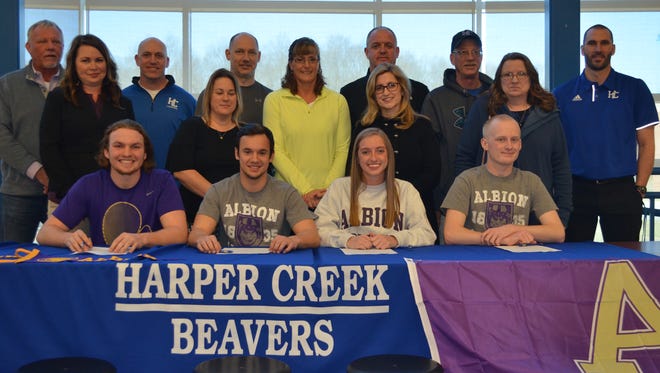 Four Harper Creek athletes signed to compete at the next level at Albion College. Sitting, from left, Joe Tatar, Drew VanWagner, Jena Wager and Devon Funk, along with family and coaches.