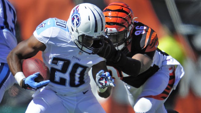 Titans running back Bishop Sankey has his face mask pulled by Bengals defensive end Carlos Dunlap during the third quarter at Paul Brown Stadium.
