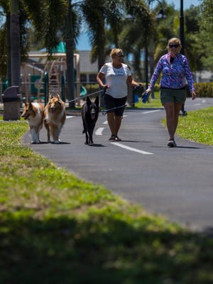 Tierney Fountaine, left, walks her dogs alonside friend Irene Windett during a visit to Joe Stonis Park in Cape Coral on Monday afternoon, April 16.