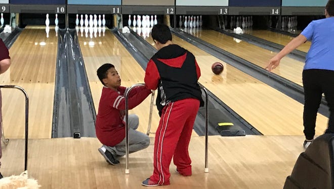 Clifton middle schooler Marcello Murphy works with a Special Olympic athlete to knock down as many pins as possible.