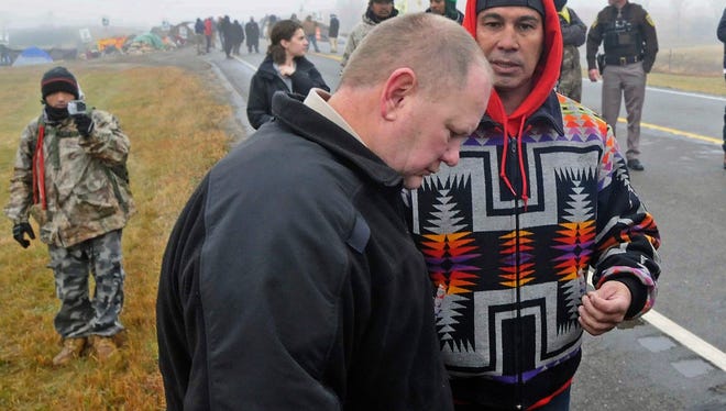 FILE - In this Oct. 26, 2016 file photo, Morton County Sheriff Kyle Kirchmeier, front, listens to Brian Wesley Horinek, of Oklahoma, outside the New Camp on Pipeline Easement in North Dakota. Kirchmeier, who has led the police response to the Dakota Access oil pipeline, is a law enforcement lifer, a veteran of the North Dakota State Patrol and National Guard before being elected to his first term as Morton County sheriff. (Tom Stromme/The Bismarck Tribune via AP, File) /The Bismarck Tribune via AP)