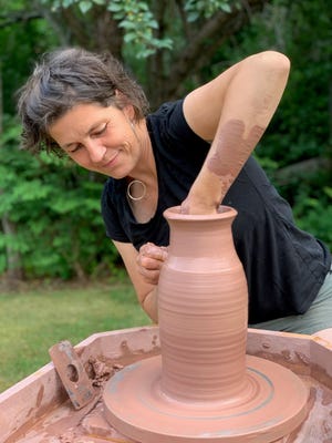Amy Clark, owner of Ocean Fire Pottery in York, Maine, moved her wheel outdoors amid the COVID-19 pandemic, so she can continue to work and meet customers at her home-based business.