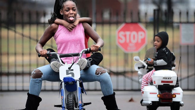 Kyla Jefferson, 13, takes her brother D'Anthony Jefferson, 6, for a ride on his new electric motorbike at the Owens Place Townhomes after opening presents on Christmas morning. After a warm wet Christmas, the Mid-South can expect continued thunderstorms and 70 degree temperatures through the week.