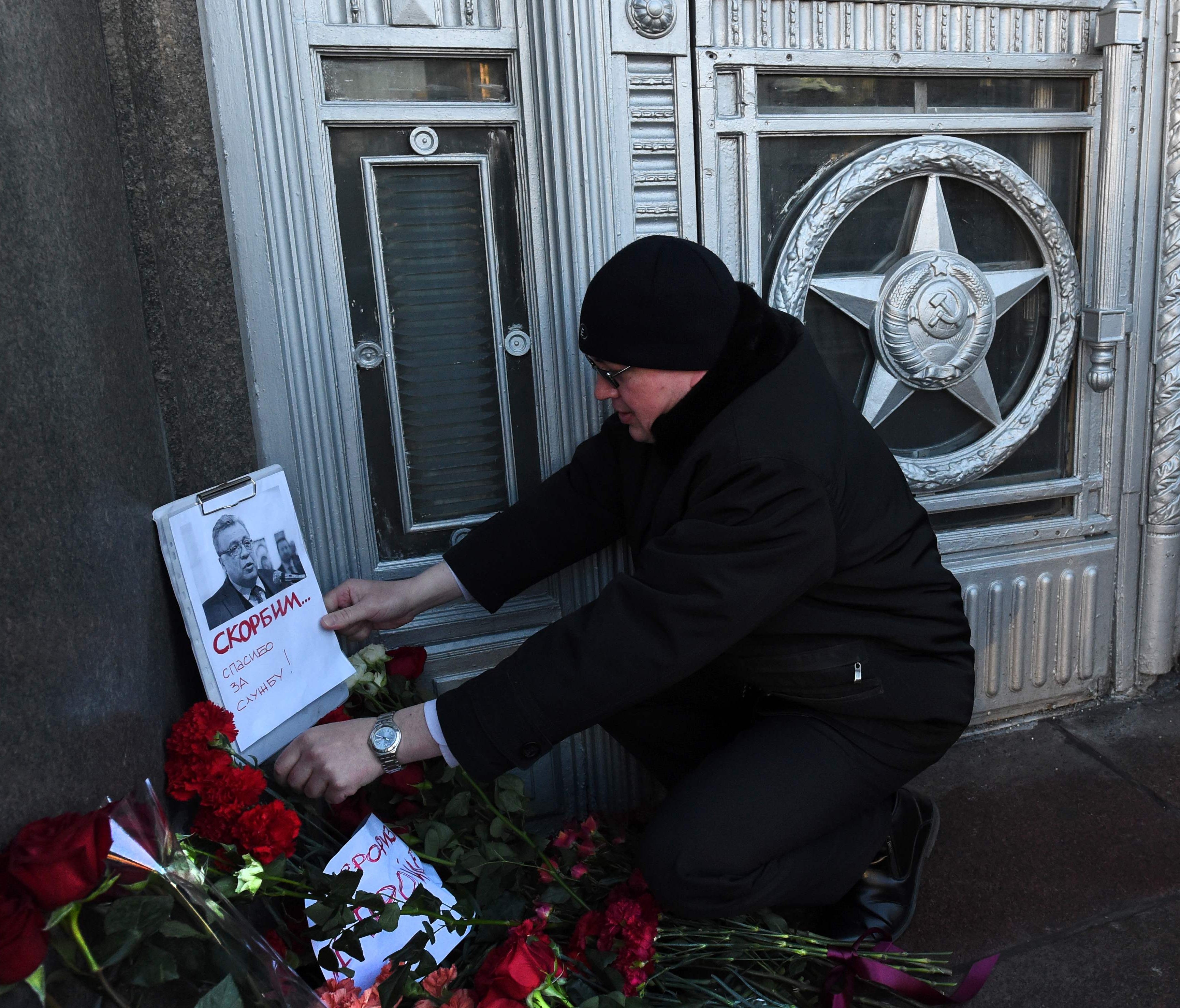 A man touches a picture of Russia's ambassador to Turkey at the Russian Foreign Ministry in Moscow on December 20, 2016, a day after his assassination in Ankara.