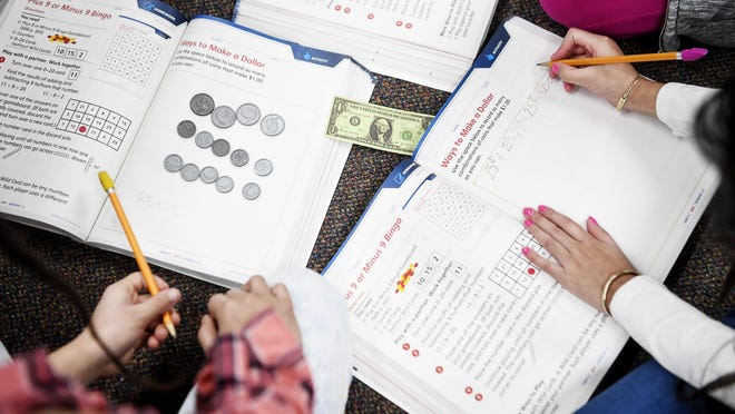 In this file photo from January, Johnston Elementary second-graders in Asheville learn how to make a dollar with coins. North Carolina parents are trying to find options to ensure their children get educated this fall as many schools operate with remote learning because of the coronavirus.