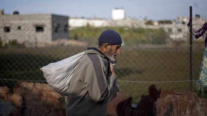 A Palestinian man carries a sack of food as he walks in the Jabalya refugee camp in the northern Gaza Strip. Tens of thousands of Palestinians are no longer getting food aid or health services from America after the Trump administration’s decision in 2018 to cut more than $200 million in aid to the Palestinians.
