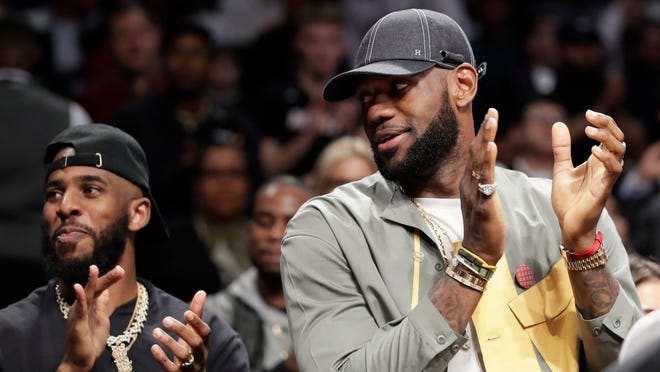 Chris Paul and LeBron James applaud during a ceremony at an NBA basketball game between the Brooklyn Nets and the Miami Heat, Wednesday, April 10, 2019, in New York. The pair were there to watch Heat guard Dwyane Wade play his last NBA game. (AP Photo/Kathy Willens)