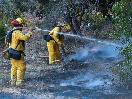 Firefighters water down burning embers from an overnight