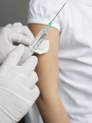 Medical professional giving vaccination shot