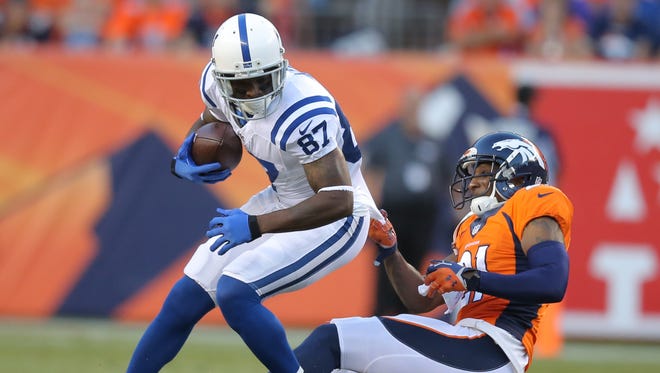 Indianapolis Colts Reggie Wayne is dragged down by Denver Broncos Aqib Talib in the first half. The Indianapolis Colts play the Denver Broncos on Sunday, September 7, 2014 at Sports Authority Field at Mile High in Denver, CO.