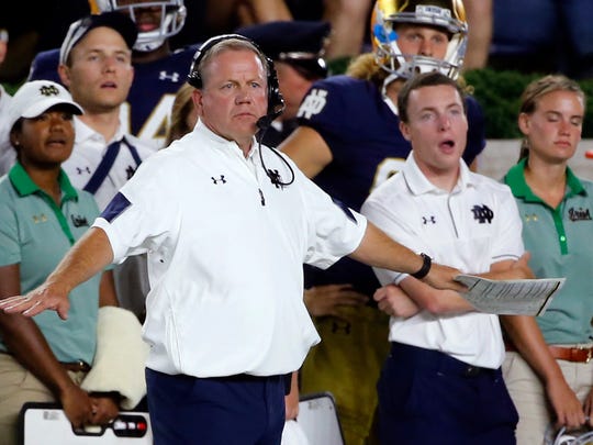 Notre Dame head coach Brian Kelly signals from the