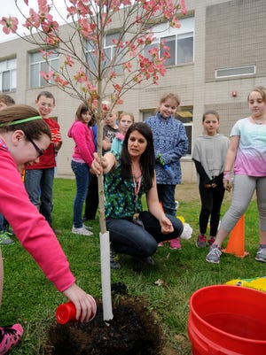 Students in the class of Christine Cauda, center, a fourth-grade teacher at West Road School in Pleasant Valley, plant a tree on Tuesday in memory of their former classmate Zain Lodhi.