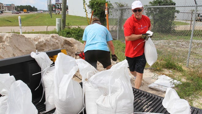 Bill and Leslie O'Brien of Vancleave, Miss., fill sandbags on Monday, June 19, 2017, at the Harrison County Road Department in Gulfport, Miss., for a friend in preparation for expected heavy rains later this week from a tropical system developing in the Gulf of Mexico.
