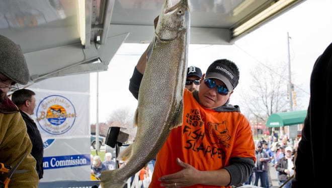 Aurelio Peña hefts a 17.3-pound lake trout  caught in Lake Huron.