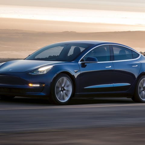 Dark-colored Tesla Model 3 automobile on an empty...
